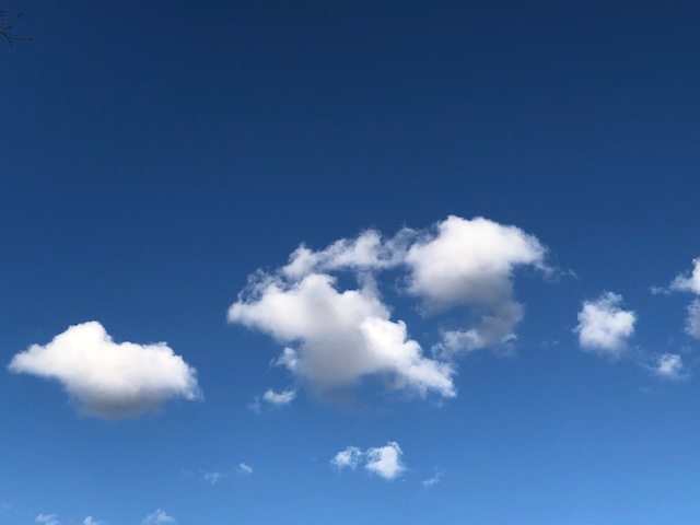 clear blue sky with a few bright clouds